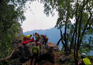 I tecnici del soccorso alpino e i sanitari imbarellano la ragazzina ferita sulle pendici del Monte Cimone